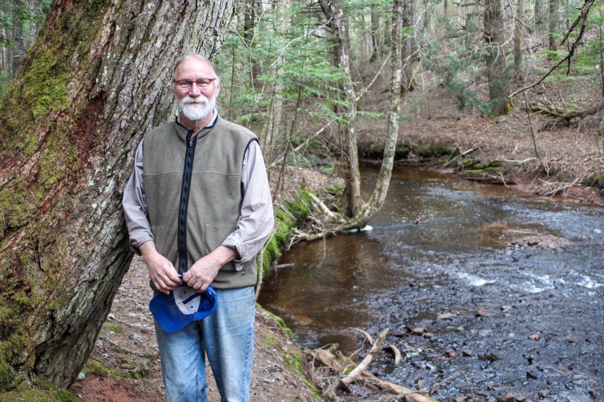 Gary Schneider poses for a picture in the woods.