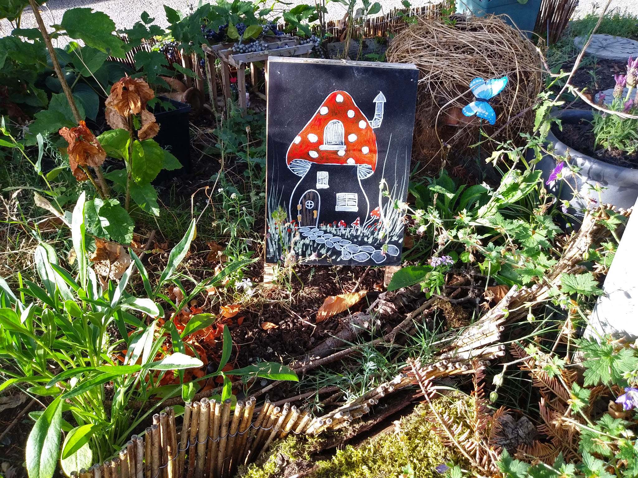 An illustration of a mushroom house in a messy garden with other art objects