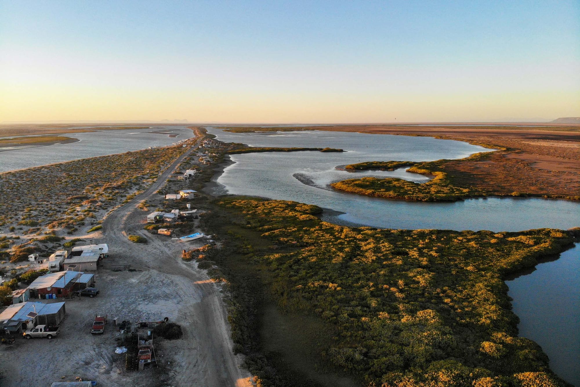 An aerial view of a village on a spit between water