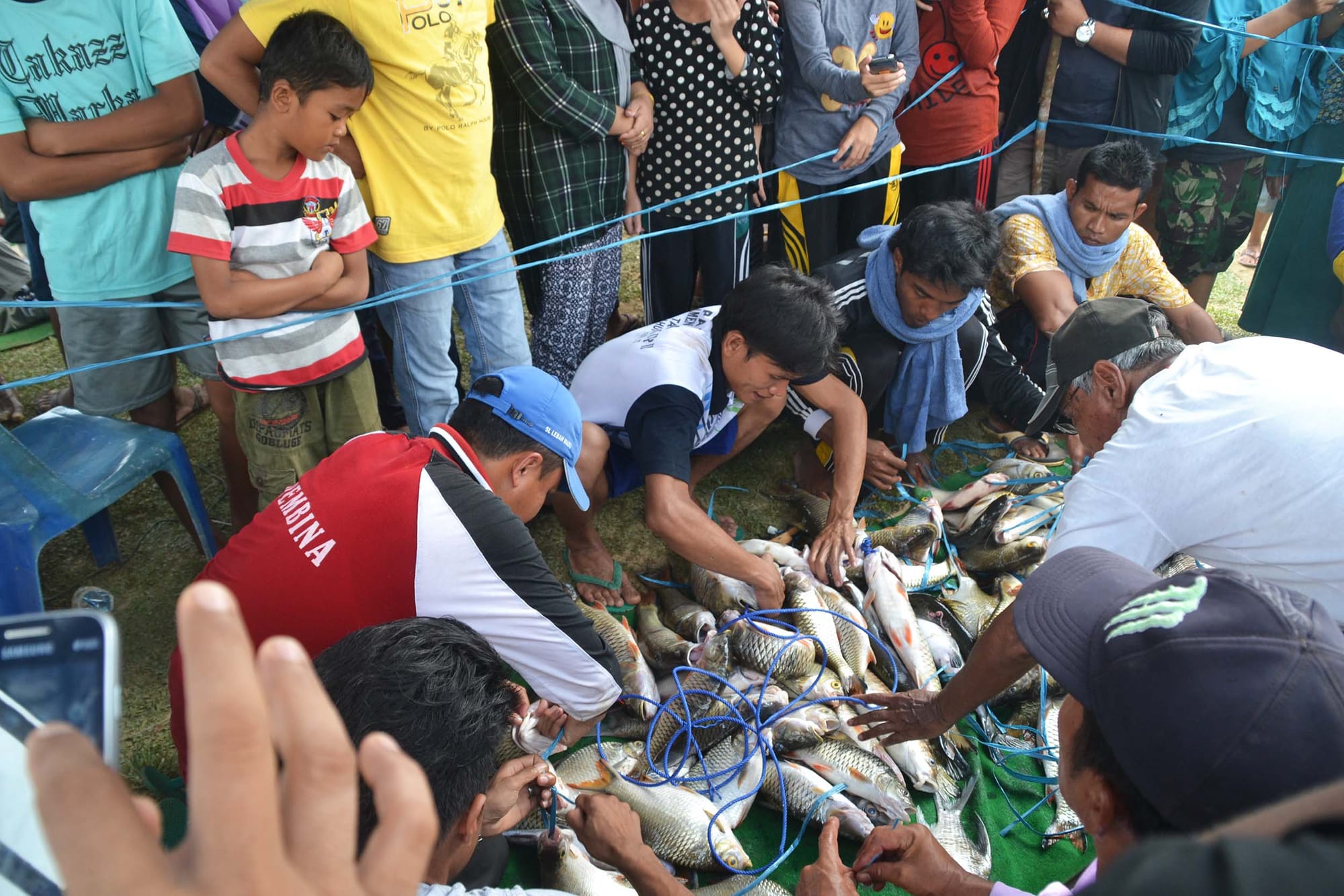 A group of people examining freshly caught fish