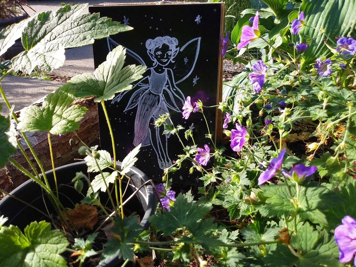 A garden with purple flowers and an illustration of a fairy